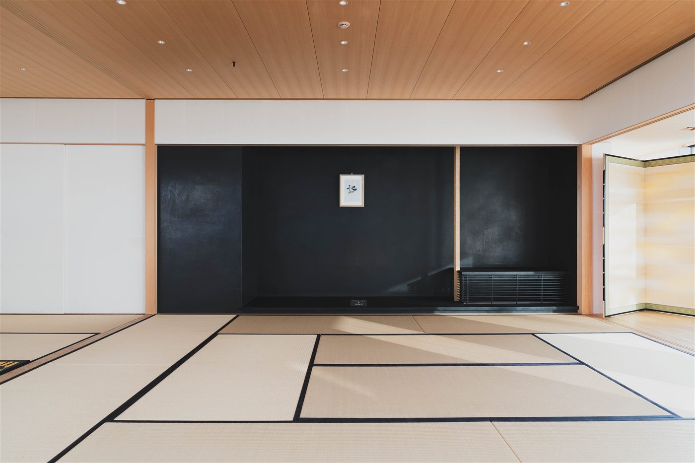 黒い壁に掛け軸が一幅だけの座敷