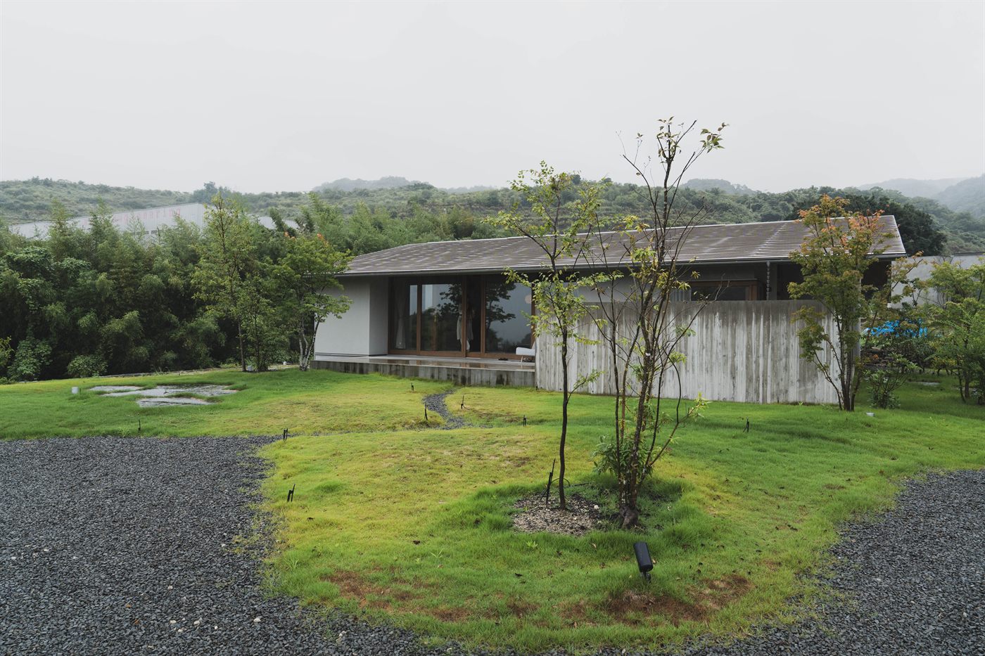 板塀に囲まれた芝生の庭と、大きく開いた窓