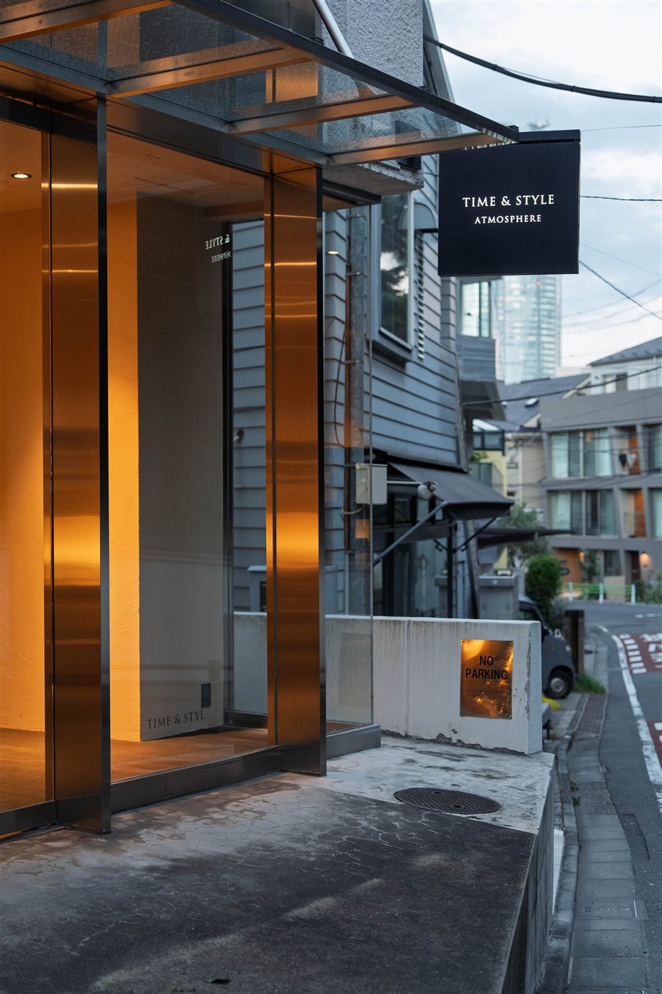 鏡面のステンレスの柱と、店の看板